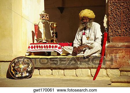 Stock Image - Senior man sitting at a veranda of a museum, Meherangarh Museum, Jodhpur, Rajasthan, India. Fotosearch