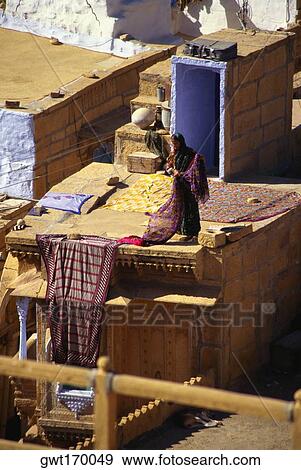 Woman drying sari on the roof of a house, Jaisalmer, Rajasthan, India View Large Photo Image Stock Photo - Woman drying sari on the roof of a house, Jaisalmer, Rajasthan, India. Fotosearch