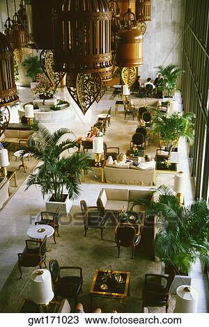 Stock Image - High angle view of a group of people sitting in a lobby, The Oriental Bangkok, Bangkok, Thailand. Fotosearch