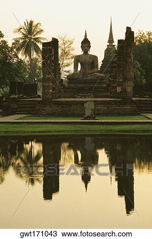 Reflection of a statue of Buddha in water, Wat mahathat, Sukhothai Historical Park, Sukhothai, Thailand View Large Photo Image Stock Image - Reflection of a statue of Buddha in water, Wat mahathat, Sukhothai Historical Park, Sukhothai, Thailand. Fotosearch