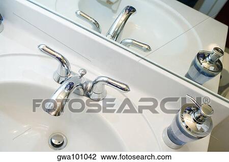 Close-up of a faucet and a soap dispenser on a bathroom sink View Large Photo Image Stock Image - Close-up of a faucet and a soap dispenser on a bathroom sink. Fotosearch