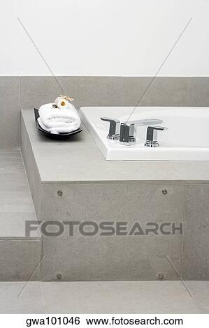 Stock Photograph - Towel near a bathtub in the bathroom. Fotosearch