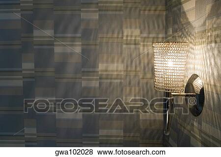 Stock Photo - Close-up of an illuminated lamp on a wall. Fotosearch