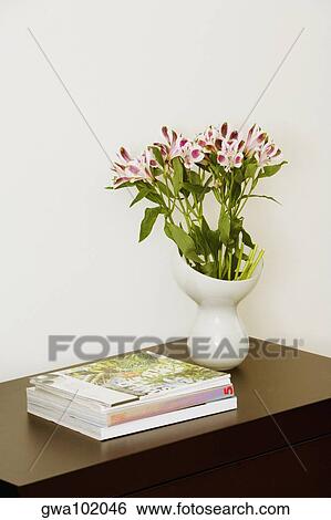 Close-up of books and a flower vase on a side table View Large Photo Image Stock Photograph - Close-up of books and a flower vase on a side table. Fotosearch