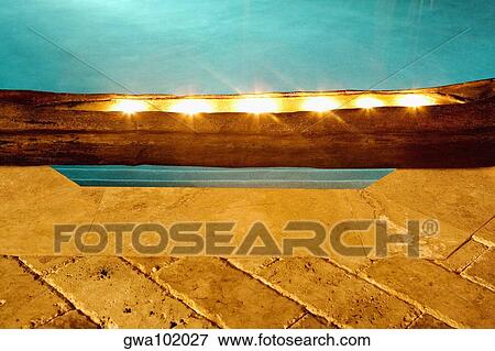 Stock Photo - Close-up of electric lights at the poolside. Fotosearch