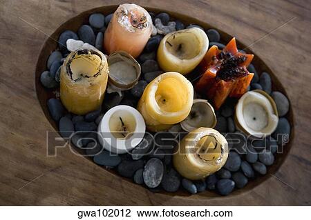 High angle view of candles and pebbles in a wooden tray View Large Photo Image Stock Image - High angle view of candles and pebbles in a wooden tray. Fotosearch