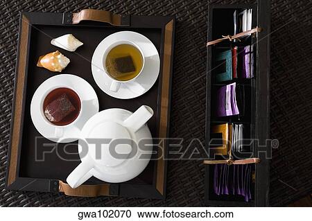 High angle view of cups of herbal tea with a teapot on a serving tray View Large Photo Image Stock Image - High angle view of cups of herbal tea with a teapot on a serving tray. Fotosearch