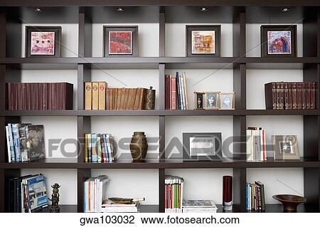 Stock Image - Books and picture frames in shelves. Fotosearch