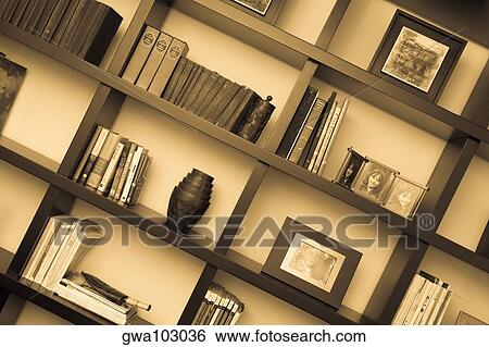 Stock Photograph - Books and picture frames in shelves. Fotosearch