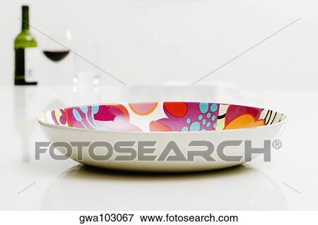 Stock Photo - Close-up of a bowl with a bottle of red wine in the background. Fotosearch
