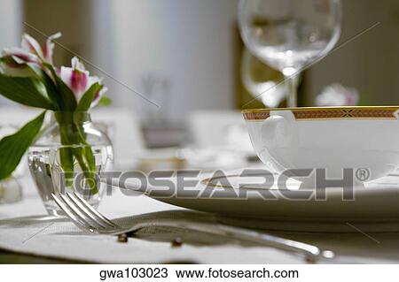 Stock Image - Close-up of a flower vase and a soup bowl on a dining table. Fotosearch