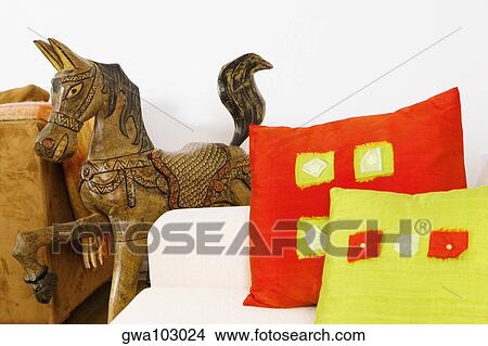 Close-up of cushions on a couch with a wooden horse View Large Photo Image Picture - Close-up of cushions on a couch with a wooden horse. Fotosearch