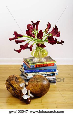 Flowers in a vase on a stack of books in a living room View Large Photo Image Stock Photo - Flowers in a vase on a stack of books in a living room. Fotosearch