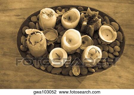 Stock Image - High angle view of candles and pebbles in a wooden tray. Fotosearch