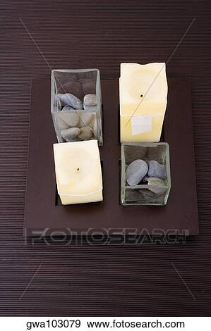 Stock Photo - High angle view of candles and pebbles on a table. Fotosearch