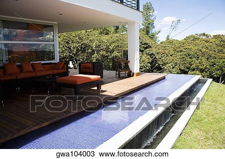 Couch and an armchair in a patio of a house View Large Photo Image Stock Image - Couch and an armchair in a patio of a house. Fotosearch