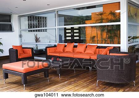 Stock Image - Couch and armchairs in a patio of a house. Fotosearch