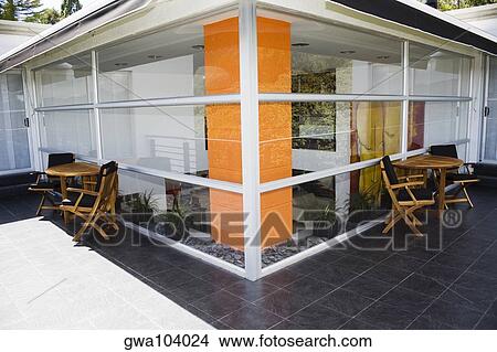 Tables and chairs outside a house View Large Photo Image Picture - Tables and chairs outside a house. Fotosearch