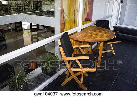 Stock Photo - Two chairs and a table outside a house. Fotosearch