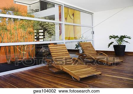 Two lounge chairs in a patio of a house View Large Photo Image Stock Image - Two lounge chairs in a patio of a house. Fotosearch