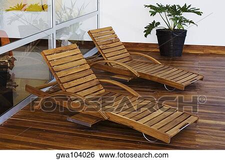 Two lounge chairs in a patio of a house View Large Photo Image Stock Photograph - Two lounge chairs in a patio of a house. Fotosearch