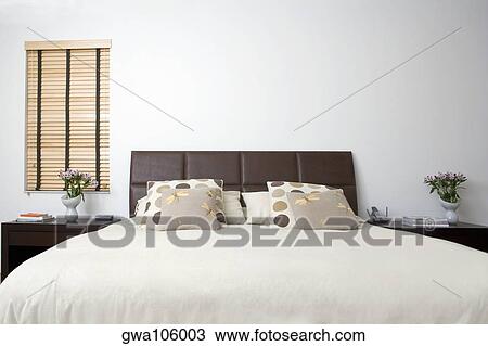 Bed and side tables in a bedroom View Large Photo Image Stock Image - Bed and side tables in a bedroom. Fotosearch