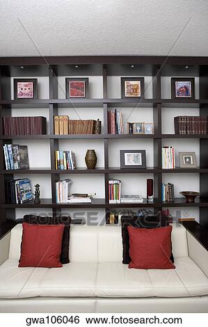 Couch in front of shelves in a living room View Large Photo Image Stock Photograph - Couch in front of shelves in a living room. Fotosearch