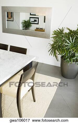 Stock Photo - Houseplant and a dining table in a dining room. Fotosearch