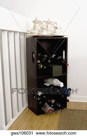Stock Image - Silver teapots on a wine rack. Fotosearch