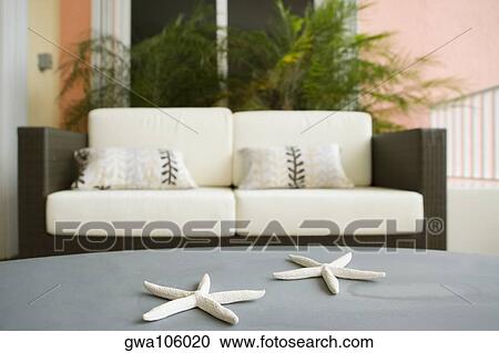 Stock Image - Toy star fish on a table with a couch in the background. Fotosearch