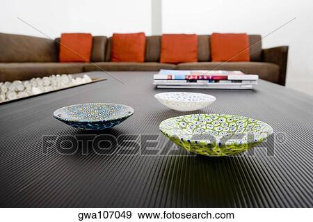 Stock Photo - Ceramic bowls and magazines on a table. Fotosearch