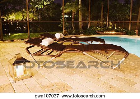 Empty lounge chairs at the poolside View Large Photo Image Stock Photo - Empty lounge chairs at the poolside. Fotosearch