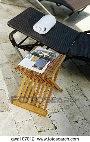 High angle view of lounge chairs and a table at the poolside View Large Photo Image Stock Image - High angle view of lounge chairs and a table at the poolside. Fotosearch