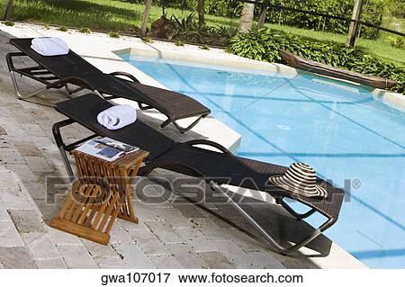Lounge chairs at the poolside View Large Photo Image Stock Photo - Lounge chairs at the poolside. Fotosearch