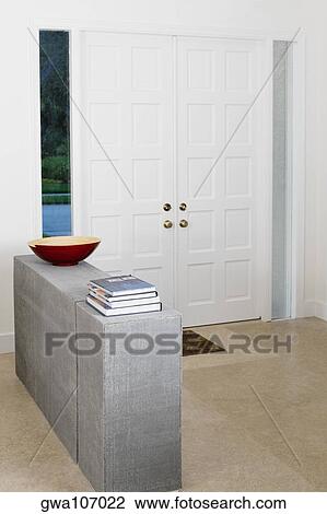 Stack of books and decorative urn on the ledge in a room View Large Photo Image Stock Image - Stack of books and decorative urn on the ledge in a room. Fotosearch