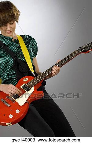 Close-up of a female guitarist playing a guitar View Large Photo Image Stock Image - Close-up of a female guitarist playing a guitar. Fotosearch