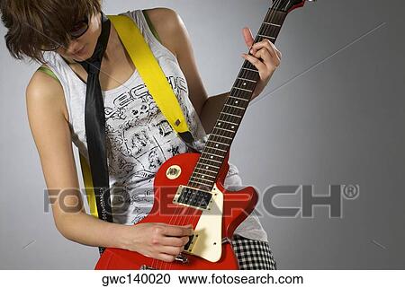 Close-up of a female guitarist playing a guitar View Large Photo Image Stock Image - Close-up of a female guitarist playing a guitar. Fotosearch
