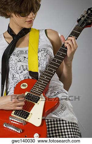 Close-up of a female guitarist playing a guitar View Large Photo Image Stock Image - Close-up of a female guitarist playing a guitar. Fotosearch