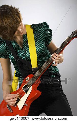Close-up of a female guitarist playing a guitar View Large Photo Image Stock Photo - Close-up of a female guitarist playing a guitar. Fotosearch