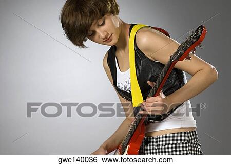Close-up of a female guitarist playing a guitar View Large Photo Image Stock Photograph - Close-up of a female guitarist playing a guitar. Fotosearch