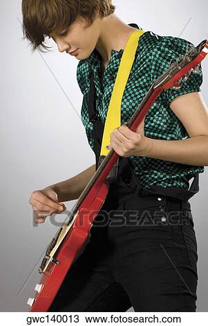 Stock Image - Close-up of a guitarist playing a guitar. Fotosearch