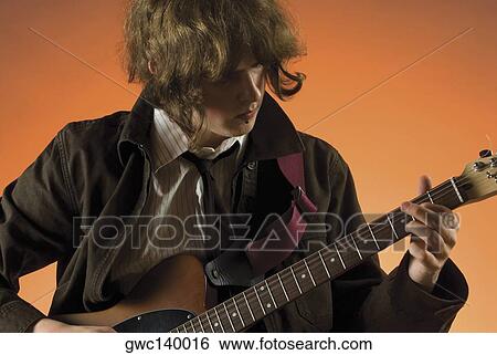 Stock Photograph - Close-up of a guitarist playing a guitar. Fotosearch