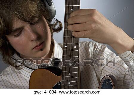 Close-up of a guitarist playing a guitar View Large Photo Image Picture - Close-up of a guitarist playing a guitar. Fotosearch