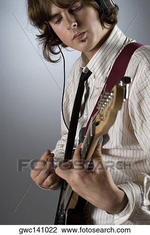 Close-up of a guitarist playing a guitar View Large Photo Image Stock Image - Close-up of a guitarist playing a guitar. Fotosearch