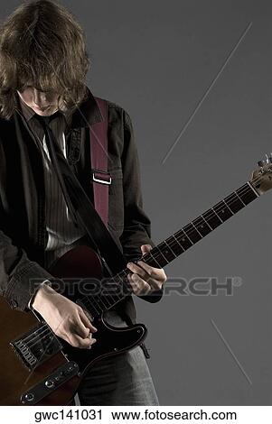 Close-up of a guitarist playing a guitar View Large Photo Image Stock Image - Close-up of a guitarist playing a guitar. Fotosearch