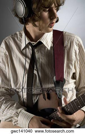 Close-up of a guitarist playing a guitar View Large Photo Image Stock Image - Close-up of a guitarist playing a guitar. Fotosearch