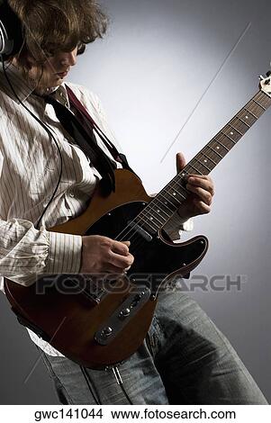 Close-up of a male guitarist playing a guitar View Large Photo Image Picture - Close-up of a male guitarist playing a guitar. Fotosearch