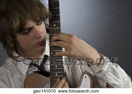 Close-up of a male guitarist playing a guitar View Large Photo Image Stock Image - Close-up of a male guitarist playing a guitar. Fotosearch