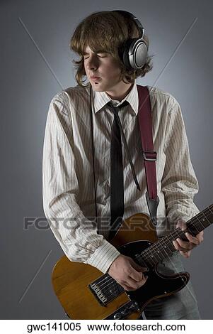 Stock Photography - Close-up of a male guitarist playing a guitar. Fotosearch