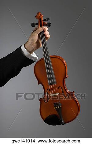 Picture - Close-up of a musician's hand holding a violin. Fotosearch